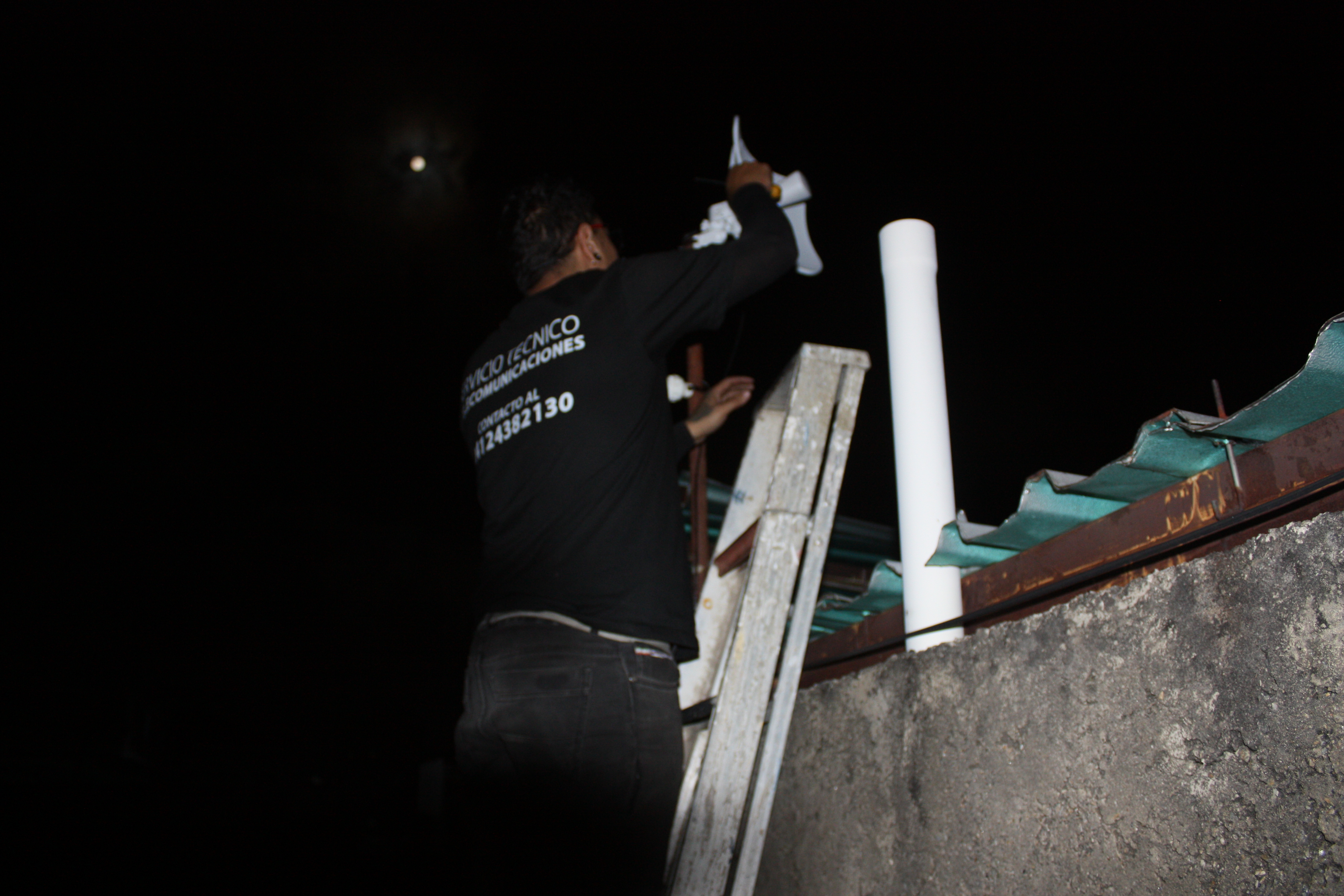 Técnico de LowLatency instalando servicio de internet en la noche